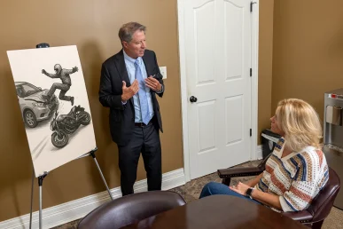 Tom McCutcheon explains a motorcycle accident case in Athens, Alabama, to a client using an illustration for clarity.