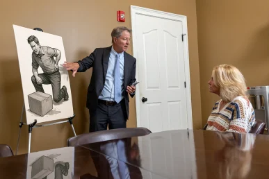 Tom McCutcheon with client review their workers’ compensation case in Florence Alabama.